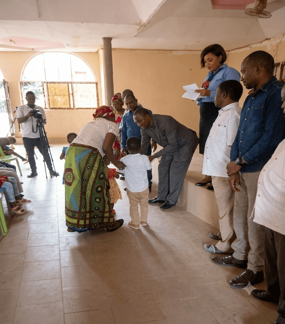 UPSDE staff and community members assisting a family with birth certificate registration in a community hall